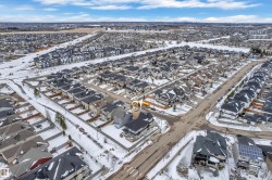 Aerial view of a residential community featuring numerous single-family homes with dark roofs - 