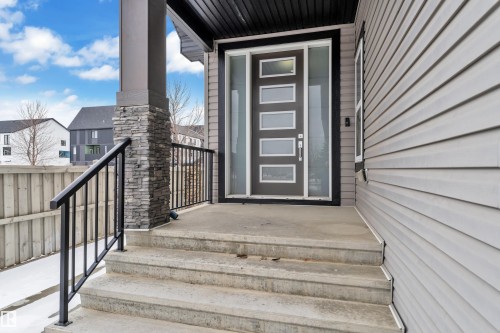 Modern entry featuring a gray door with five frosted glass panels and a full-light sidelight - 3702 Claxton Place, Edmonton, AB - Outdoor With Exterior