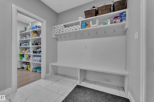 Mudroom featuring a built-in bench, wall-mounted hooks, and overhead shelving - 3702 Claxton Place, Edmonton, AB - Indoor