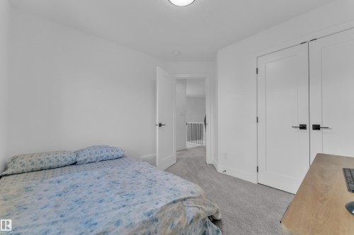 Bright interior room featuring light gray carpet flooring, white walls, and a white flush-mount ceiling light fixture - 9 Hunter Place, Spruce Grove, AB - Indoor Photo Showing Bedroom