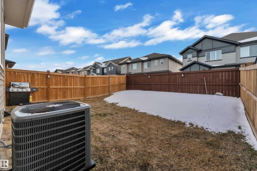 Private backyard featuring a full wood fence enclosure, an external HVAC unit, and a small patch of residual snow - 9 Hunter Place, Spruce Grove, AB - Outdoor
