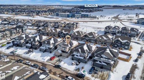 Contemporary neighborhood featuring varied architectural styles and a nearby school building - 9 Hunter Place, Spruce Grove, AB - Outdoor With View