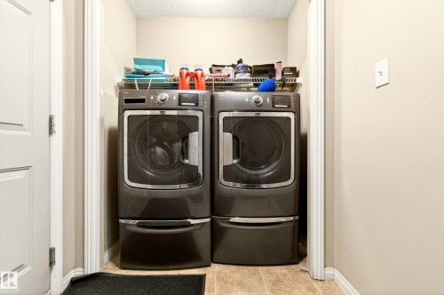Dedicated laundry area featuring a front-load washer and dryer set - 8922 5Av, Edmonton, AB - Indoor Photo Showing Laundry Room