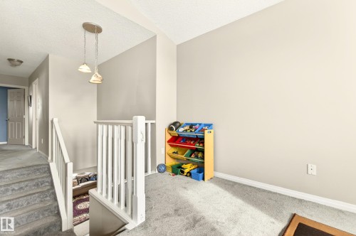 Upper landing with vaulted ceiling, neutral wall paint, and gray carpet - 8922 5Av, Edmonton, AB - Indoor Photo Showing Other Room