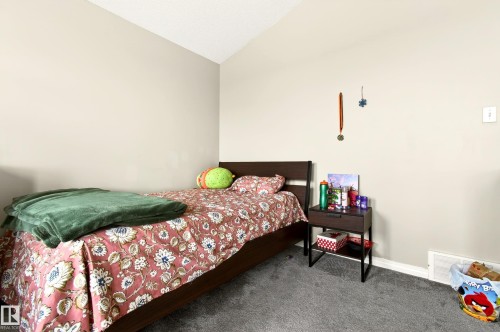 Neutral toned walls with textured ceiling and wall-to-wall carpeting - 8922 5Av, Edmonton, AB - Indoor Photo Showing Bedroom