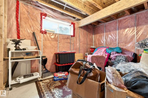 Unfinished basement space with exposed wooden joists and framing, insulated walls, and a visible egress window - 8922 5Av, Edmonton, AB - Indoor Photo Showing Basement