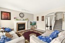 Living area featuring a white mantel fireplace with a tile surround, track lighting, and an arched entryway - 8922 5Av, Edmonton, AB  - Indoor Photo Showing Living Room With Fireplace 
