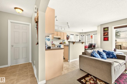 Living area featuring a light beige color palette, textured ceiling, and recessed lighting - 8922 5Av, Edmonton, AB - Indoor