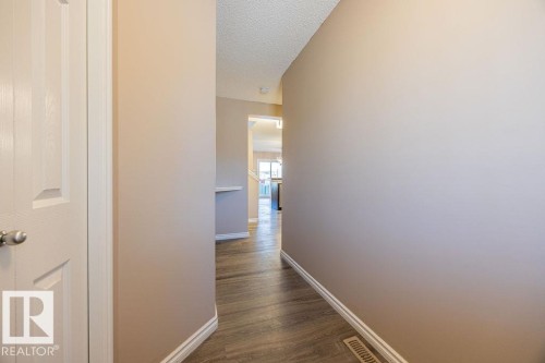 Entryway with wood-finish flooring, light tan walls, and white trim - 14 9350 211 Street, Edmonton, AB - Indoor Photo Showing Other Room