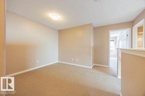 Versatile interior space featuring neutral wall tones and a textured ceiling - 14 9350 211 Street, Edmonton, AB - Indoor Photo Showing Other Room