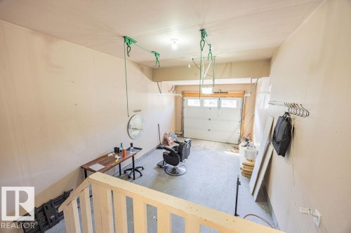 Spacious garage with light beige walls and a white paneled garage door - 14 9350 211 Street, Edmonton, AB - Indoor Photo Showing Garage