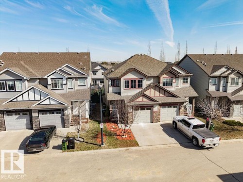 Two-story residence featuring light gray siding with dark trim accents and a brown shingled roof - 14 9350 211 Street, Edmonton, AB - Outdoor With Facade