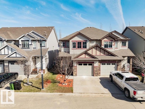 Contemporary multi-story residence featuring a combination of siding and stone veneer, multiple gables, and a prominent front entry - 14 9350 211 Street, Edmonton, AB - Outdoor With Facade