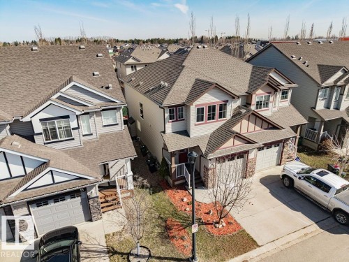 Contemporary multi-level residence featuring a double-car garage, stone and siding exterior accents, and a covered front entry - 14 9350 211 Street, Edmonton, AB - Outdoor