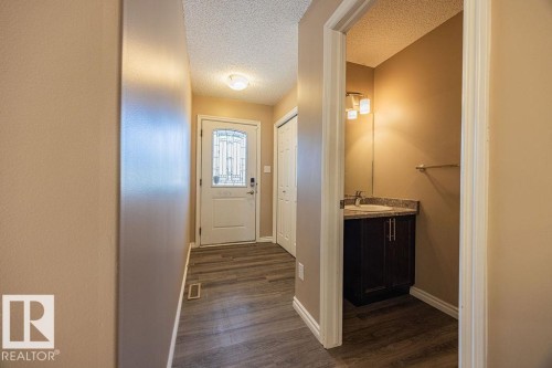 Entryway featuring wood-finish flooring, a white door with decorative glass, and a flush-mount ceiling light - 14 9350 211 Street, Edmonton, AB - Indoor Photo Showing Other Room