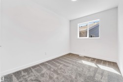 Bright interior room featuring a window with white trim, white walls, and plush grey carpeting - 