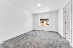 Spacious room with gray plush carpeting, white walls, and bright overhead lighting - 
