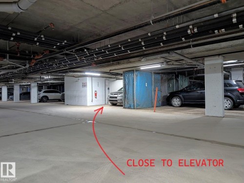 Underground parking space with concrete flooring and exposed ceiling pipes - 324 13111 140 Avenue, Edmonton, AB - Indoor Photo Showing Garage