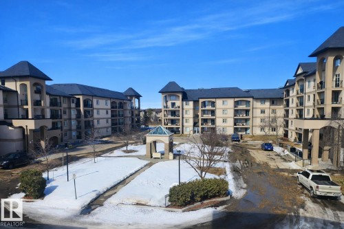 This property offers a courtyard with a gazebo and paved pathways, surrounded by multi-story buildings featuring balconies - 324 13111 140 Avenue, Edmonton, AB - Outdoor With Balcony With Facade