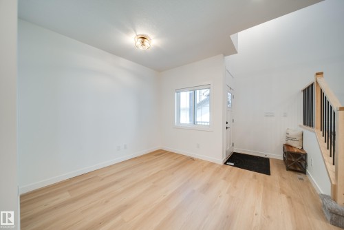 Light wood-finish flooring complements the crisp white walls and trim - 16 Blackbird Bend, Fort Saskatchewan, AB - Indoor Photo Showing Other Room