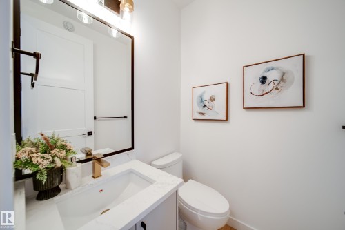 Well-appointed bathroom featuring a modern vanity with a white countertop, rectangular under-mount sink, and a gold-tone faucet - 16 Blackbird Bend, Fort Saskatchewan, AB - Indoor Photo Showing Bathroom