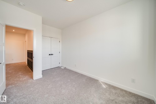 Neutral carpet flooring and white painted walls - 16 Blackbird Bend, Fort Saskatchewan, AB - Indoor Photo Showing Other Room