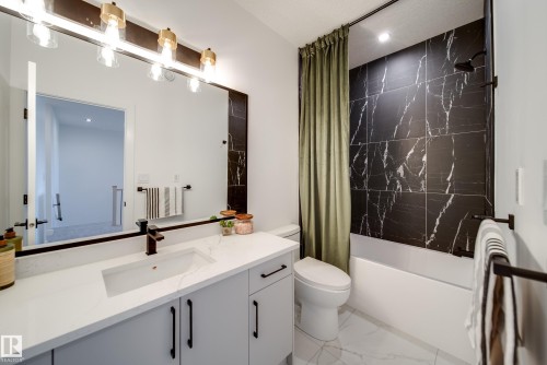 Modern bathroom featuring a single vanity with a white countertop, undermount sink, and matte black faucet - 16 Blackbird Bend, Fort Saskatchewan, AB - Indoor Photo Showing Bathroom