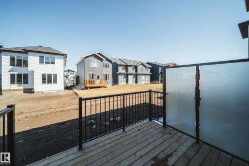 Wood-finish deck featuring black metal railings and frosted privacy panels - 16 Blackbird Bend, Fort Saskatchewan, AB - Outdoor With Deck Patio Veranda