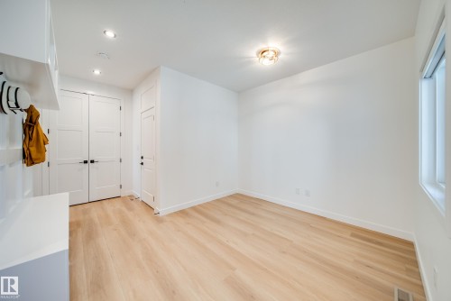 Bright interior space featuring light wood-finish flooring, recessed lighting, and a modern ceiling fixture - 16 Blackbird Bend, Fort Saskatchewan, AB - Indoor Photo Showing Other Room