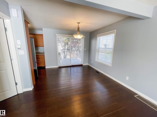 Spacious room with dark wood-finish flooring, light-toned walls, and white trim - 5806 118 Avenue Nw, Edmonton, AB - Indoor Photo Showing Other Room