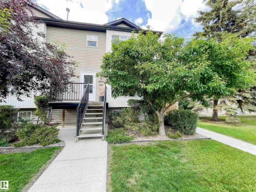 Townhome exterior featuring siding, upper-level entry with steps, and a balcony - 5806 118 Avenue Nw, Edmonton, AB - Outdoor