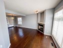 Spacious interior featuring wood-finish flooring, a built-in fireplace with a stone-finish surround, and an integrated display niche - 5806 118 Avenue Nw, Edmonton, AB  - Indoor Photo Showing Living Room With Fireplace 