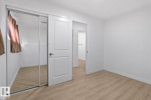 Bedroom featuring light wood-finish flooring, white painted walls, and white baseboards - 1566 Lakewood Road Nw, Edmonton, AB - Indoor Photo Showing Other Room