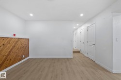 Spacious interior area featuring wood-finish flooring, white walls, and recessed lighting - 
