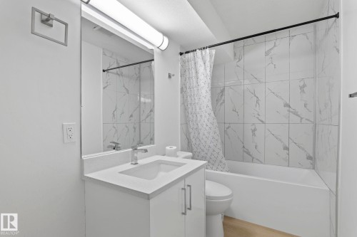Bathroom featuring a white vanity with an integrated sink, polished chrome faucet, and a large rectangular mirror - 1566 Lakewood Road Nw, Edmonton, AB - Indoor Photo Showing Bathroom