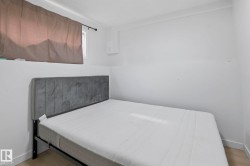 Bedroom featuring light wood-finish flooring, white walls, and white baseboards - 