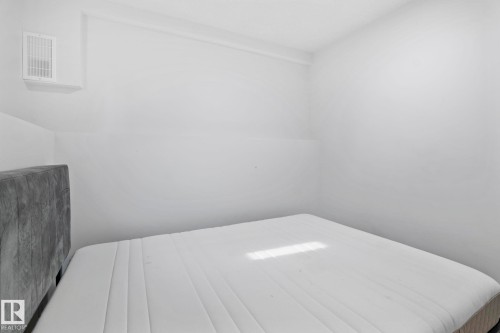 White wall finishes with a mounted ventilation unit - 1566 Lakewood Road Nw, Edmonton, AB - Indoor
