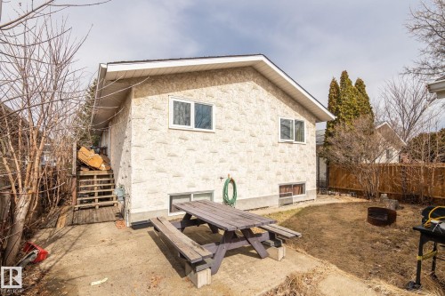 Rear exterior of the property featuring textured stucco siding and a gable roofline - 1566 Lakewood Road Nw, Edmonton, AB - Outdoor