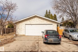 Detached two-car garage featuring a white panel door and concrete driveway - 