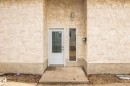 Recessed entryway featuring textured stucco with a shell pattern, a glass-panel entry door, and a vertical glass sidelight - 1566 Lakewood Road Nw, Edmonton, AB  - Outdoor 