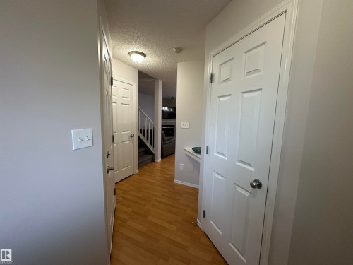Entryway featuring wood-finish flooring, light gray wall tones, and white six-panel doors - 97 2021 Grantham Crest, Edmonton, AB - Indoor Photo Showing Other Room