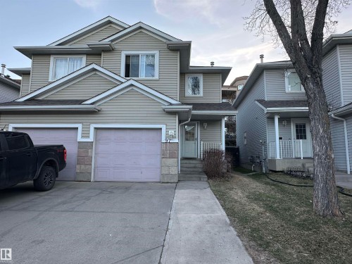 Two-story residential dwelling featuring light-toned horizontal siding and a multi-gabled roofline - 97 2021 Grantham Crest, Edmonton, AB - Outdoor With Facade