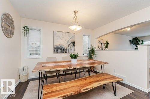 Dining area featuring dark wood flooring, light-colored walls, and windows providing natural illumination - 2828 21 Avenue, Edmonton, AB - Indoor Photo Showing Dining Room