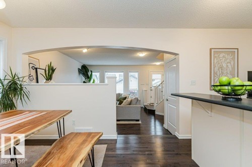 The property features dark hardwood flooring throughout, an arched doorway, and an entryway with a staircase - 2828 21 Avenue, Edmonton, AB - Indoor