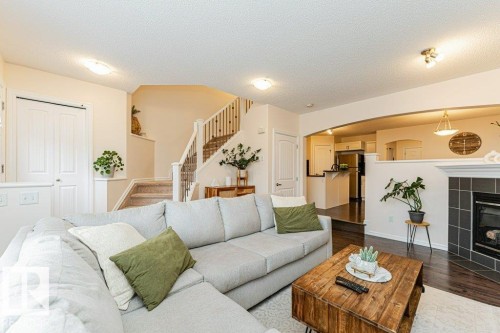 The living area features light-colored walls, recessed lighting, and a fireplace with dark tile surround - 2828 21 Avenue, Edmonton, AB - Indoor Photo Showing Living Room With Fireplace