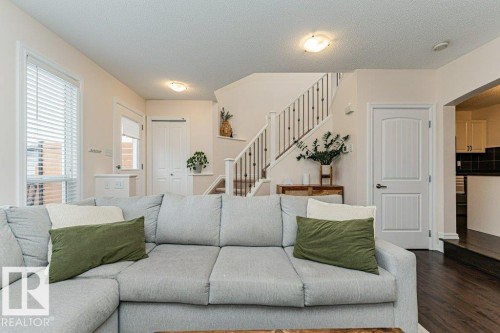 Inviting living area featuring a large window with blinds and dark wood flooring - 2828 21 Avenue, Edmonton, AB - Indoor Photo Showing Living Room