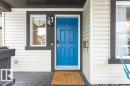 Welcoming front entrance with a vibrant blue door, white siding, and dark trim details - 2828 21 Avenue, Edmonton, AB  - Outdoor With Exterior 