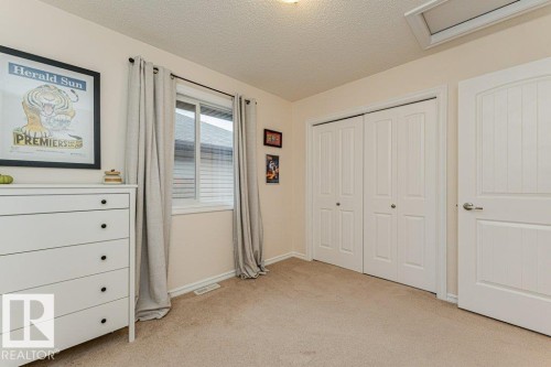 This room features carpeted flooring, a window with curtains, and a bi-fold closet - 2828 21 Avenue, Edmonton, AB - Indoor