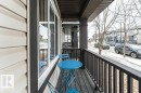 Inviting front porch with a dark railing and columns, offering views of the street and houses - 2828 21 Avenue, Edmonton, AB  - Outdoor With Exterior 