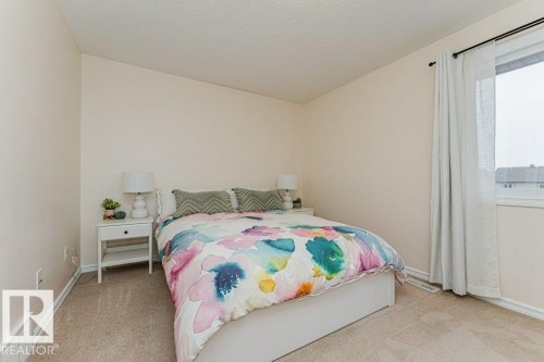 Bedroom with light beige walls, carpeted flooring, and a window with curtains - 2828 21 Avenue, Edmonton, AB - Indoor Photo Showing Bedroom